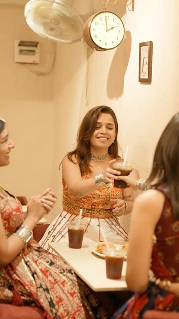 Friends in festive outfits sharing drinks at a table